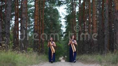 两个女<strong>竖琴</strong>手在森林里散步，在松树的背景下演奏<strong>竖琴</strong>。
